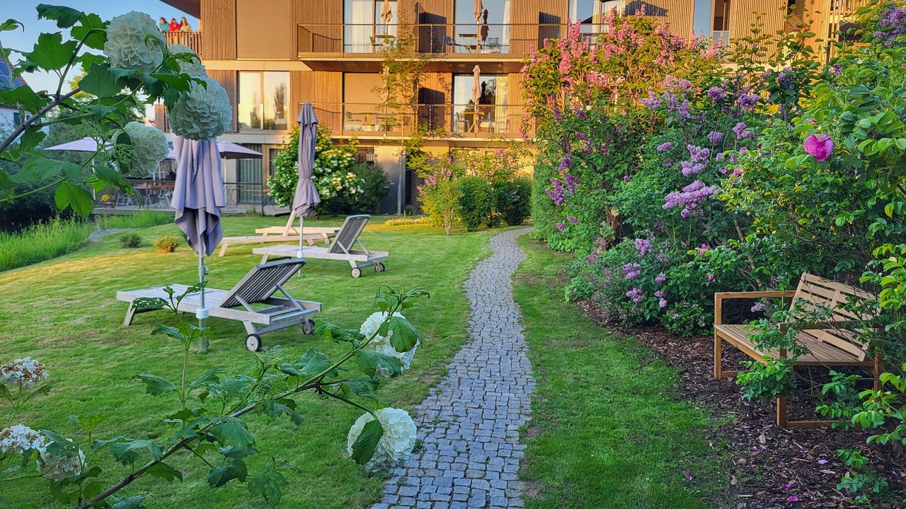 Gebäudeansicht mit Garten im Frühling Gebäudeansicht mit Garten im Frühling